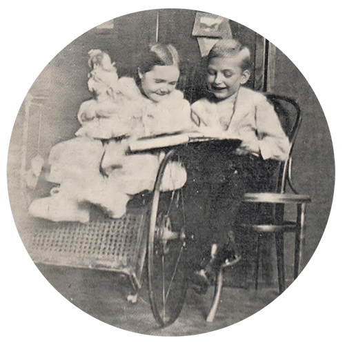 Black and white photo of 2 children reading a book