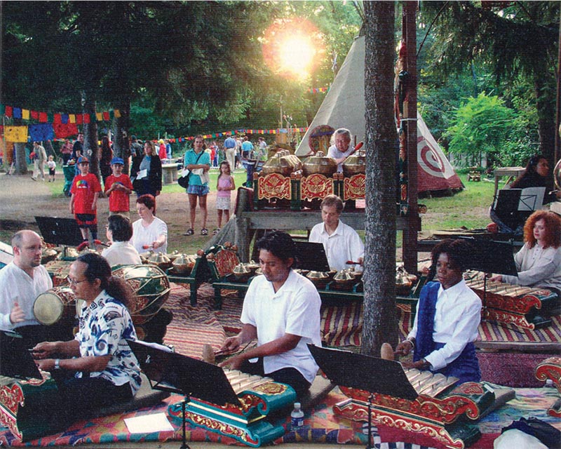 A group of people playing traditional music with instruments at an outdoor setting