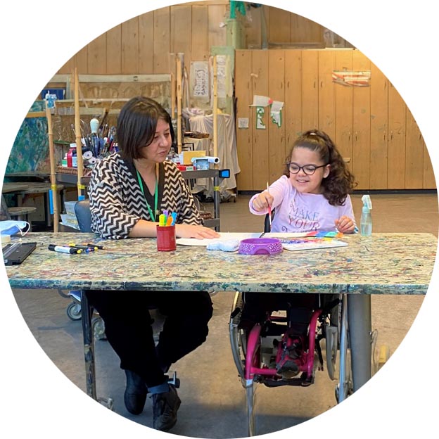 Shannon Crossman and a child on wheelchair doing some painting activities