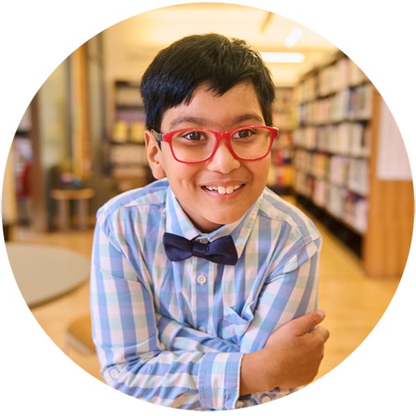 A child wearing glasses in a library setting