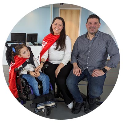 A child on wheelchair with two adults