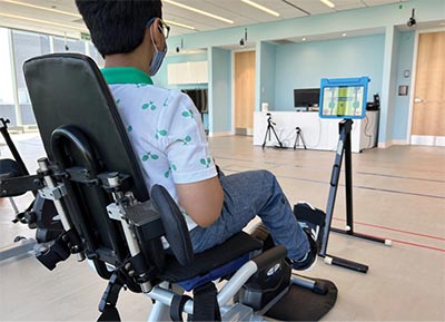 A child is sitting on a special chair and waiting for treatment